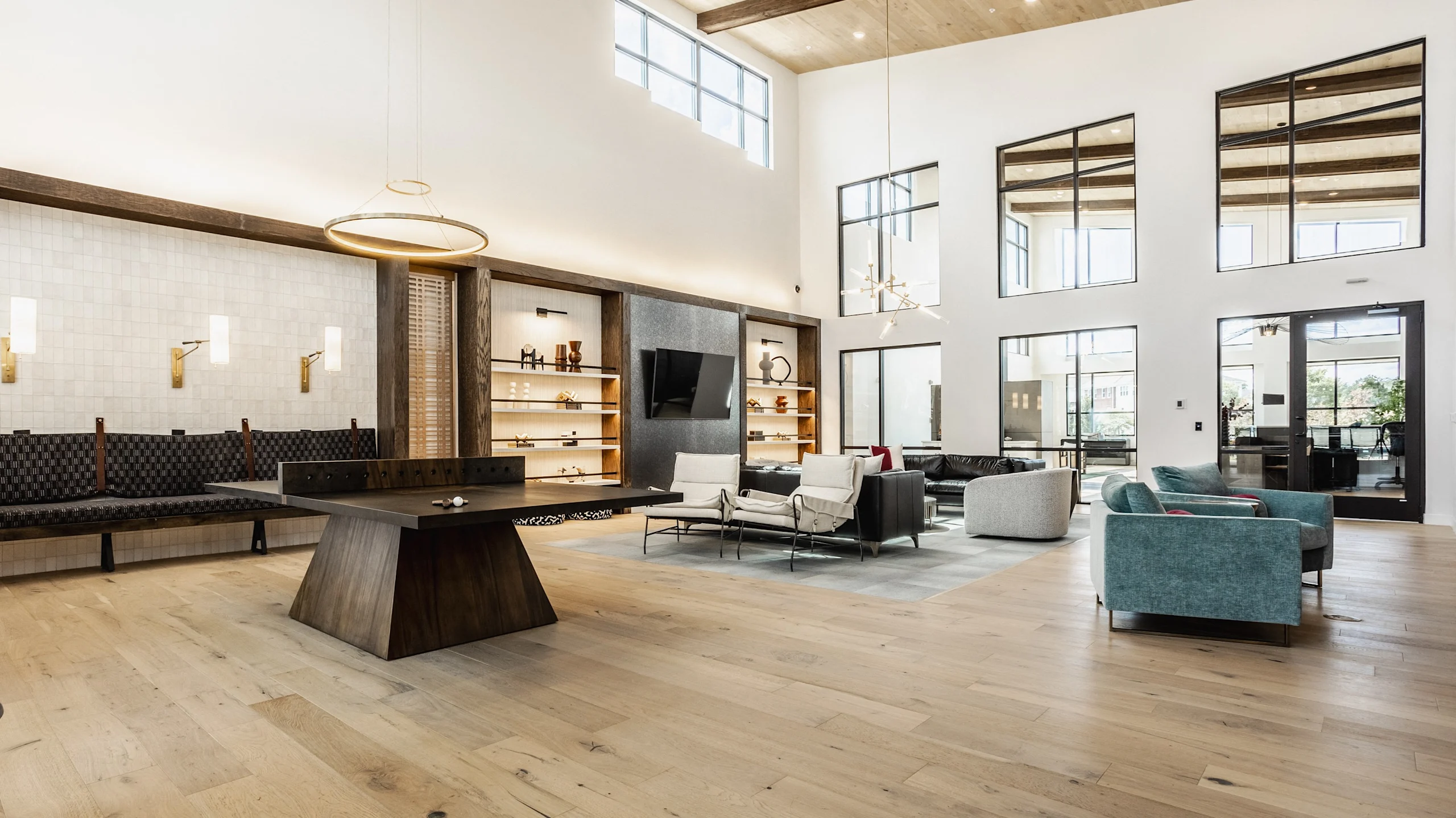 A modern apartment community lounge with warm seating and shared spaces